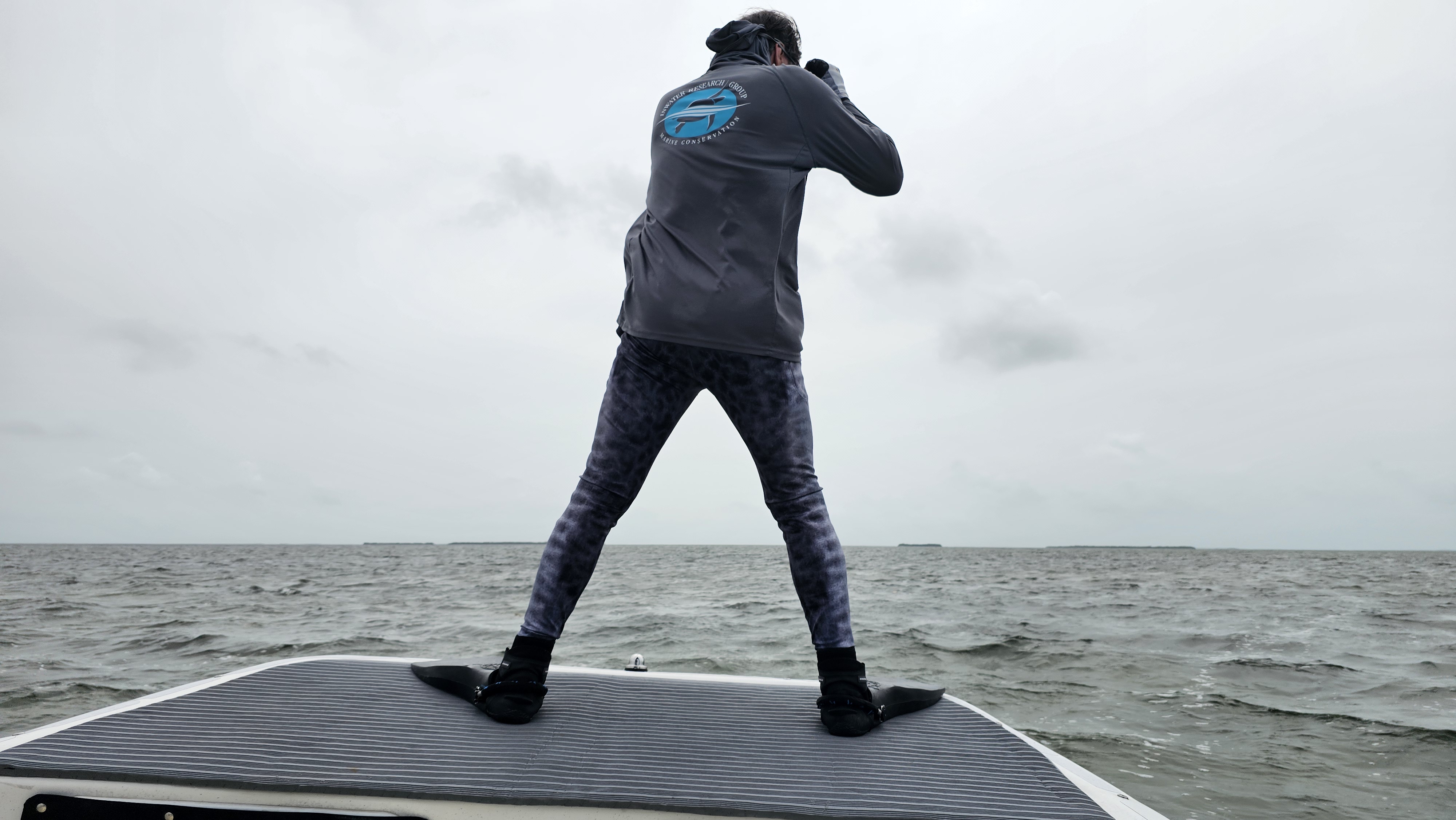 Observer standing on the bow of the research vessel scanning for sea turtles